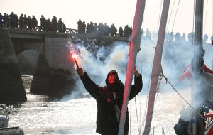 Uku Randmaa holds a flare as he celebrates his arrival to Les Sables d'Olonne