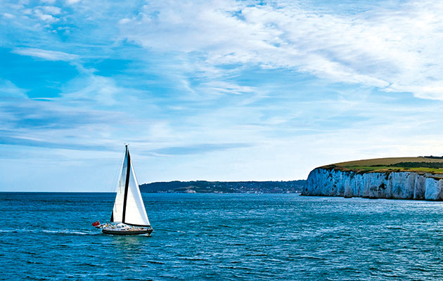 A Nordia 52 sails towards Poole past Old Harry Rocks and Swanage to the south. Photo: Gary Le Feuvre/Alamy