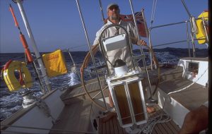 A skipper at the helm of a yacht