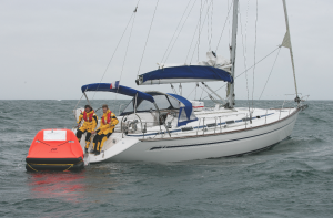 Two crew on a yacht preparing to get into a liferaft