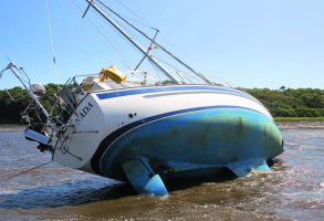 A yacht that has run aground on a river