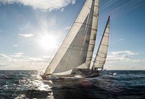 Pen Duick VI sailing with the sun behind her sails