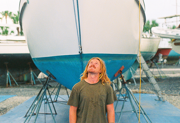 Elliott Smith standing underneath the bow of his boat