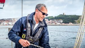 Guy Waites, one of the skippers in the 2022 Golden Globe Race, pulling on a line on his yacht