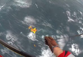 Swimmer descends to the liferaft in breaking waves; two casualties were still in the storm-battered sea after the yacht sunk. Credit: Auckland Rescue Helicopter Trust