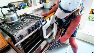 A woman looking at an oven onboard a yacht