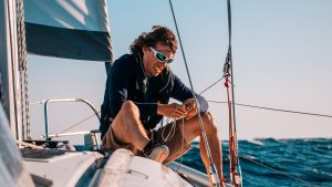 A man wearing sunglasses on the deck of a yacht