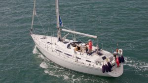 A yacht motor sailing on a blue ocean. Increasing power can help with saving fuel in strong headwinds