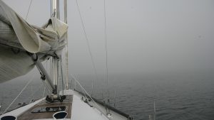 A boat sailing towards a tidal headland in poor visibility with no working engine or electrics