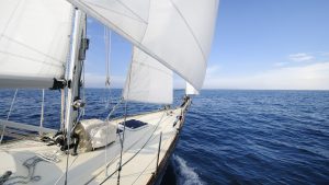 A boat with white sails sailing to France