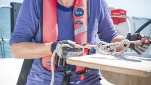 A sailor tying a knot looking at knot books