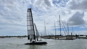 A foiling yacht sailing in a harbour while producing clean hydrogen