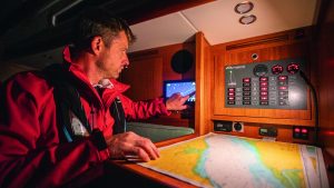 A man wearing a lifejacket using an electronic chart and chart plotter