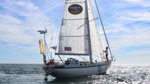 Guy Waites sailing his Tradewind 35 boat in the Golden Globe Race 2022. The hull of the boat is covered in barnacle growth