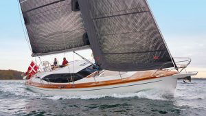 The Nordship 420 DS sailing with grey and black sails and a white hull