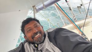 Abhilash Tomy, a sailor in the Golden Globe Race, smiling while sailing his boat