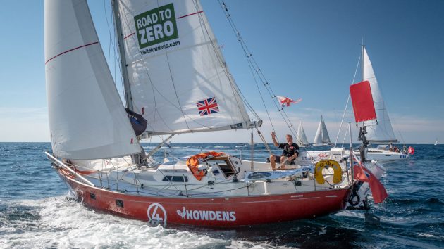 A boat at speed: Simon Curwen sailing his red hulled yacht at sea