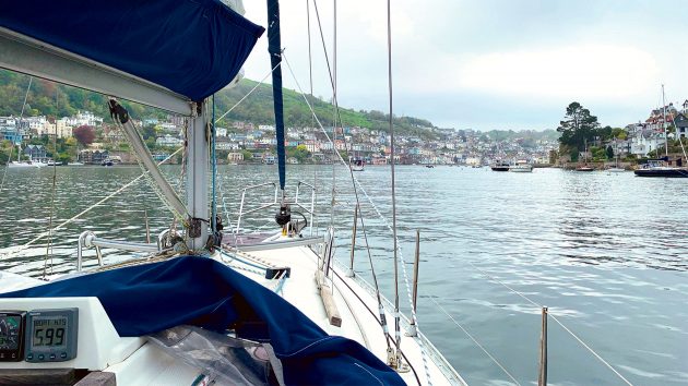 View from the boat on water with a cornish town in the distance.