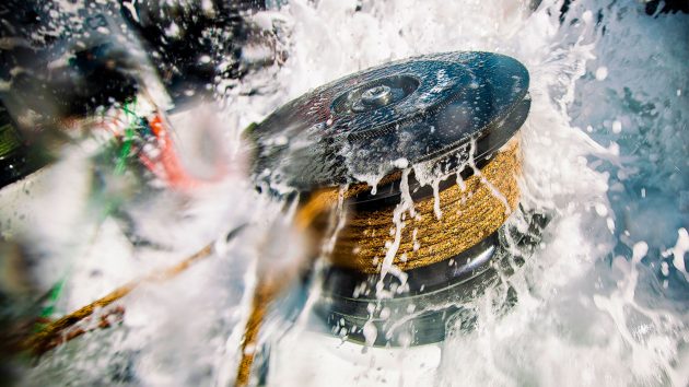 A close up of water splashing over a winch.