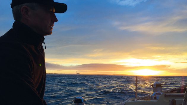 A man looking out to sea at sunset