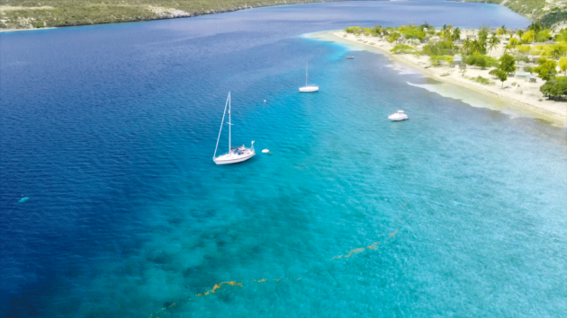 Aerial shot of a boat in azure waters