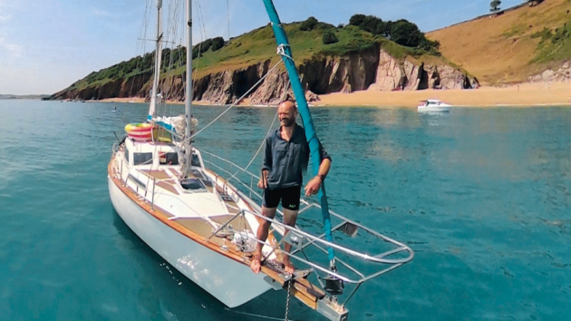 Monty aboard a yacht with cliffs in the background