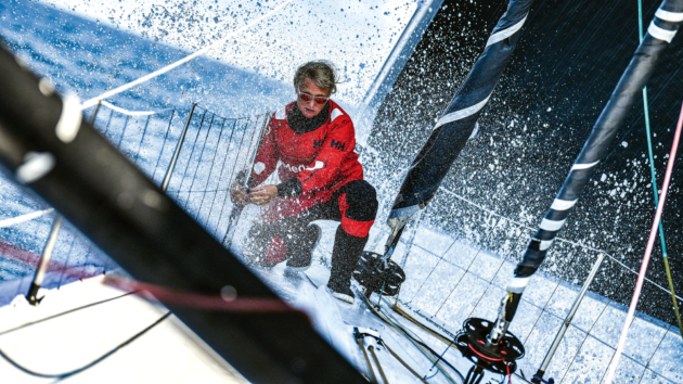 Pip Hare aboard a boat with spray splashing up