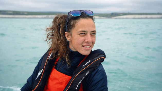 Jazz Turner wears a Teamo lifejacket, a grey sea is behind her