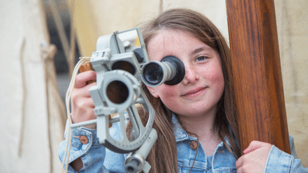 A child looking through a sextant