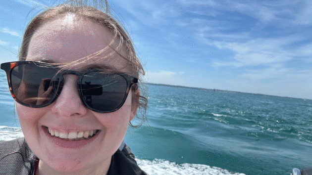 Jenny in the sunglasses with the sea behind