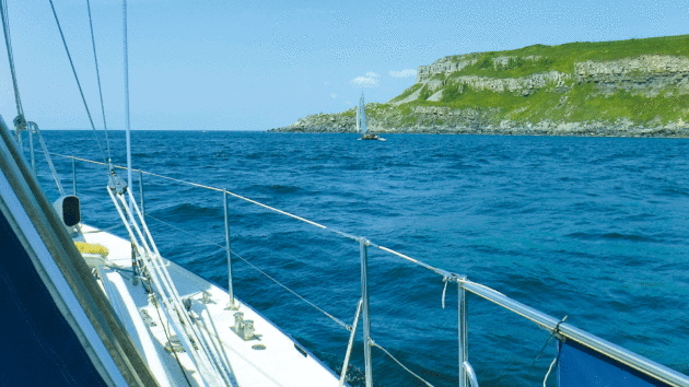 A fellow yacht also enjoys the sunshine and smooth seas as they sail past Anvil Point