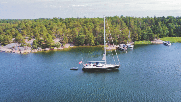 Skyelark 2 lies to anchor while smaller boats tie up bows to the rocks