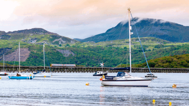 A train crosses the historic bridge over the Mawddach estuary in Barmouth, Gwynedd, Wales