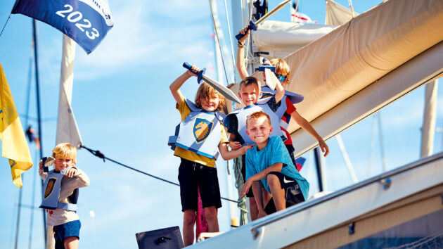 Kids grinning in costume on a yacht