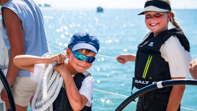 Two kids smiling on a yacht