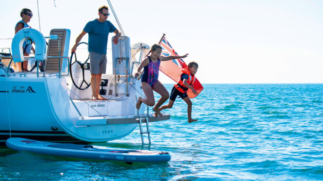 Some kids jumping off a yacht