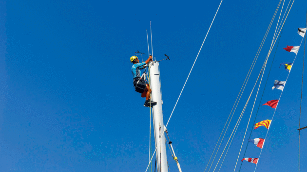 Someone in safety gear up a mast