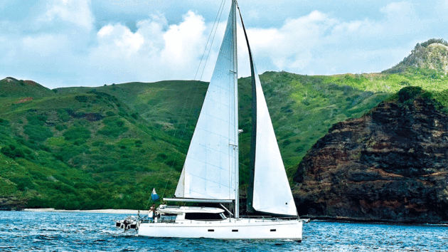 The yacht with green hills behind