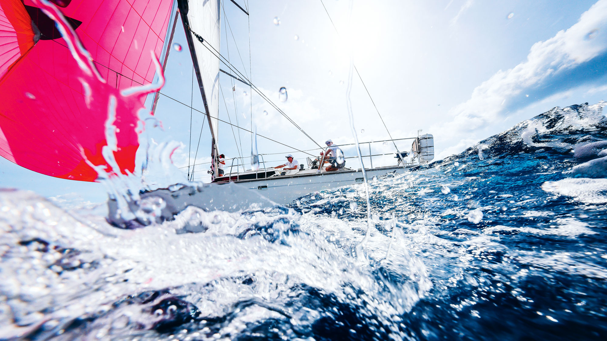 Una barca a vela in navigazione a vela in direzione del vento con equipaggio e strumenti di sicurezza
