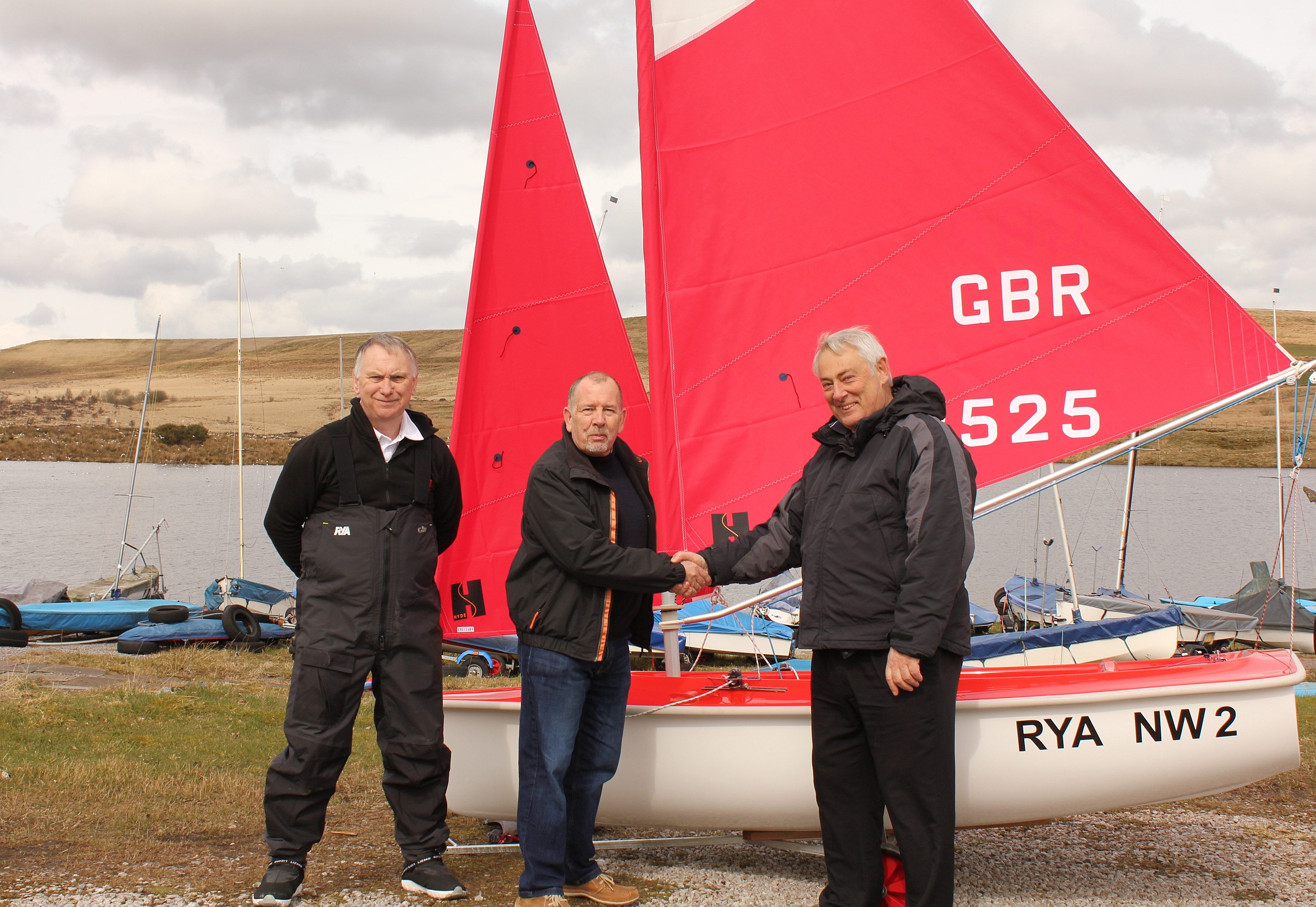 The new disabled access boat is handed over to Bolton Sailing Club. Left to right Warren Price (RYA Sailability North Development Officer), Keith Roberts (President Bolton SC), Michael Moore (Chairman RYA North West Region)