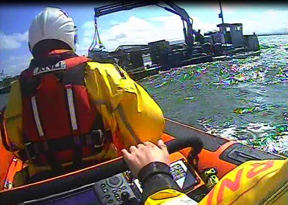 Poole Inshore Lifeboat rescuing two people when their trimaran capsized