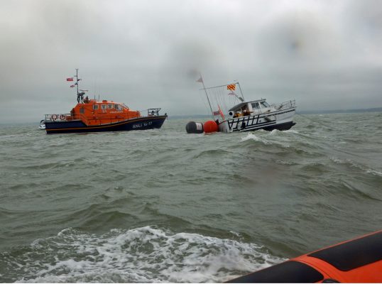 The heavily listing catamaran, Twin Wakes, with Bembridge lifeboat nearby.