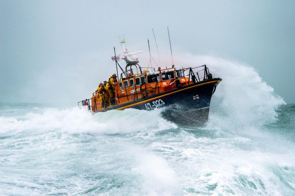 Poole Tyne class City of Sheffield 47-023 in rough seas. Large waves and lots of white spray.
