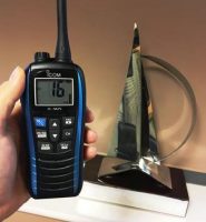 person holding Icom VHF radio