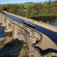 A narrowboat makes its way along the Lune Aqueduct on the Lancaster Canal