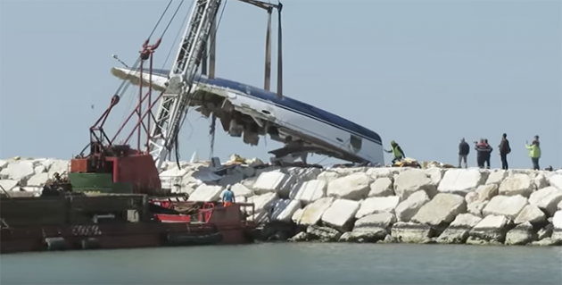 A crane lifts up the remains of a Bavaria Cruiser 50 after it was wrecked at Rimini