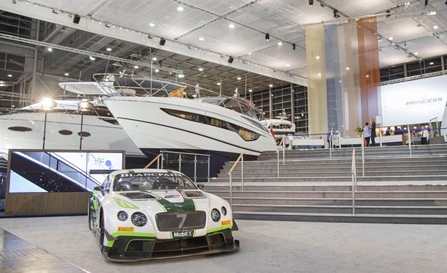 A Bentley car in front of a luxury yacht