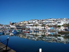 A harbour at Brixham during the summer, with boats moored