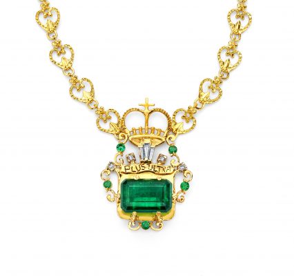 A bright green emerald set in a gold necklace