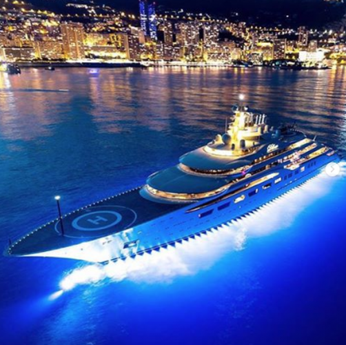 A superyacht lit up at night in port